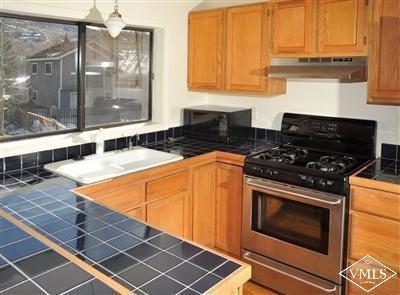 22 Spruce Circle Edwards, CO 81632 - Photo 5 of 7 a kitchen with granite countertop a stove top oven cabinetry a sink and a window