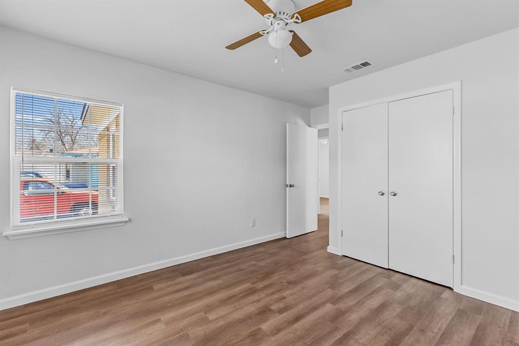 2117 Frazier Street Greenville, TX 75401 - Photo 12 of 25 a view of an empty room with wooden floor and a window