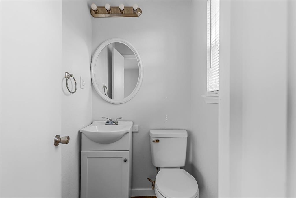 2117 Frazier Street Greenville, TX 75401 - Photo 17 of 25 a bathroom with a toilet sink and mirror