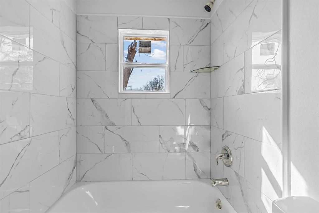 2117 Frazier Street Greenville, TX 75401 - Photo 20 of 25 a bath tub sitting in a bathroom next to a window