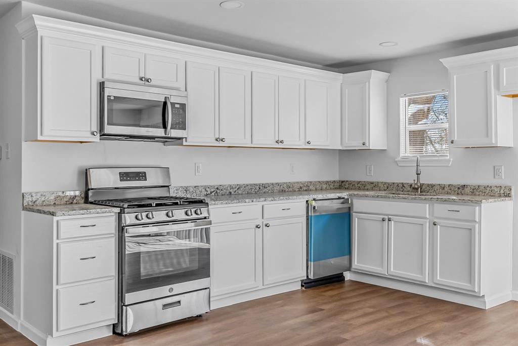 2117 Frazier Street Greenville, TX 75401 - Photo 5 of 25 a kitchen with granite countertop white cabinets and appliances