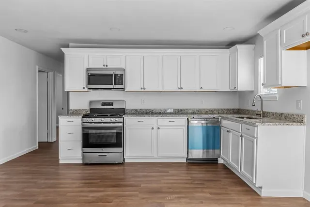 a kitchen with granite countertop a stove and a sink