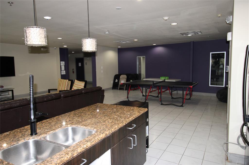 1100 West Trinity Mills Road, Unit 3035 Carrollton, TX 75006 - Photo 6 of 12 a kitchen with kitchen island granite countertop a sink a counter top space and living room view