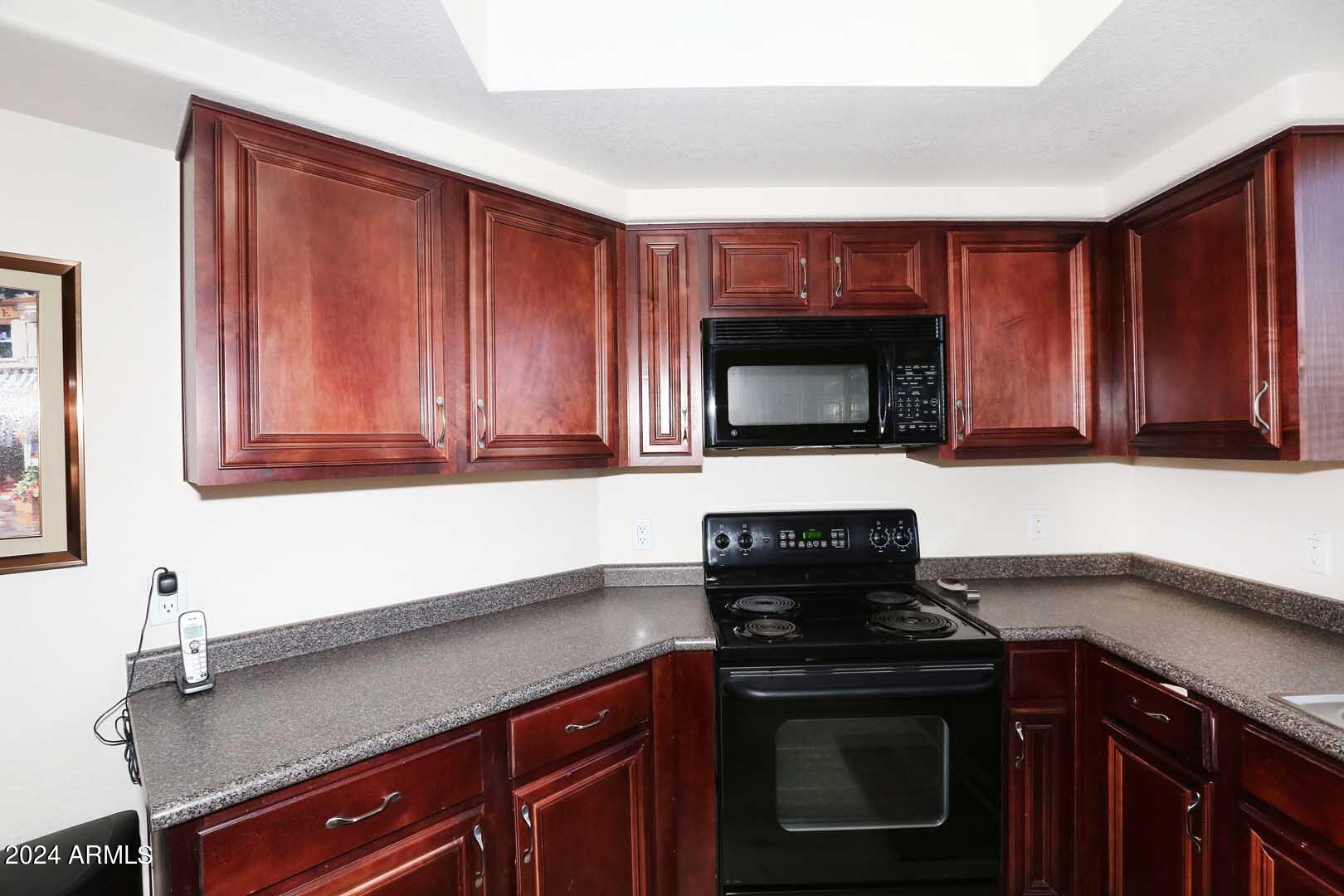4925 East Desert Cove Avenue, Unit 363 Scottsdale, AZ 85254 - Photo 11 of 47 a kitchen with granite countertop a stove top oven cabinetry a sink and dishwasher