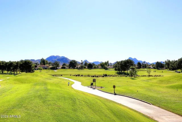 a sign on the field of grass and trees