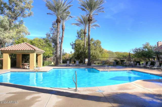 a view of a house with swimming pool and sitting area