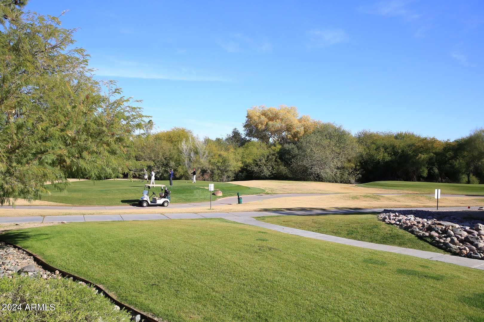 4925 East Desert Cove Avenue, Unit 363 Scottsdale, AZ 85254 - Photo 46 of 47 a view of a swimming pool with lawn chairs and large trees