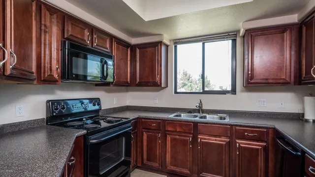 a kitchen with stainless steel appliances granite countertop a stove a sink and a microwave
