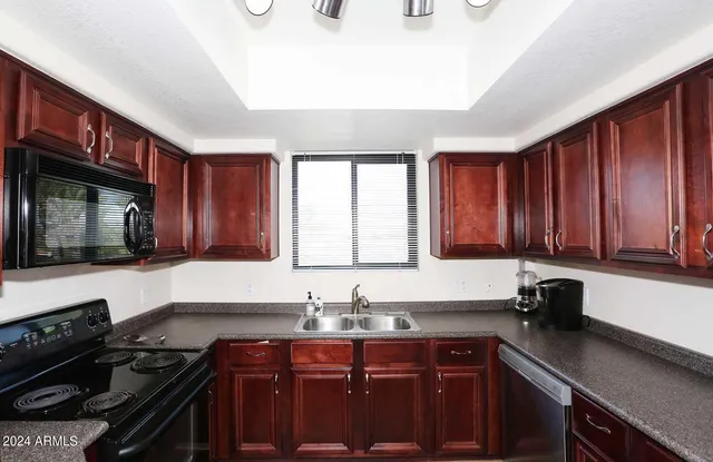 a kitchen with a sink stove top oven and cabinets