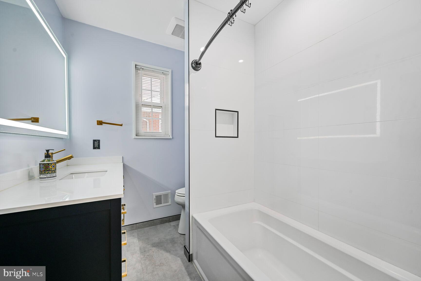 1323 Fernway Road Northwest Washington, DC 20012 - Photo 17 of 24 a bathroom with a bathtub sink vanity mirror and toilet