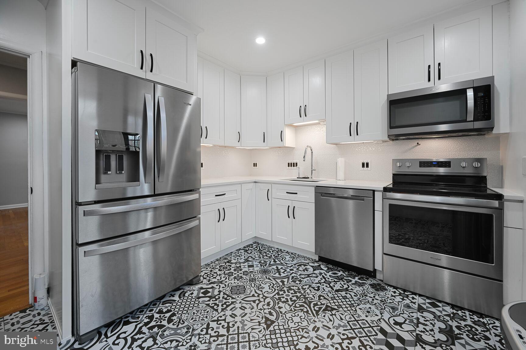 1323 Fernway Road Northwest Washington, DC 20012 - Photo 3 of 24 a kitchen with stainless steel appliances and white cabinets