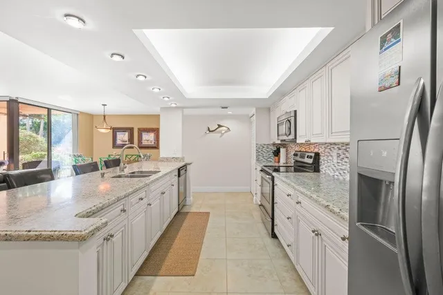 a large kitchen with stainless steel appliances granite countertop a lot of counter space and wooden floors