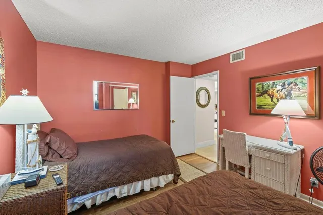 a bedroom with a bed and a lamp with the dresser