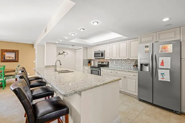 a kitchen with stainless steel appliances granite countertop a refrigerator and a stove top oven