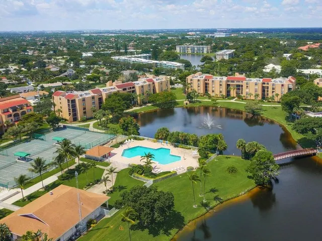 an aerial view of residential houses with outdoor space and lake view