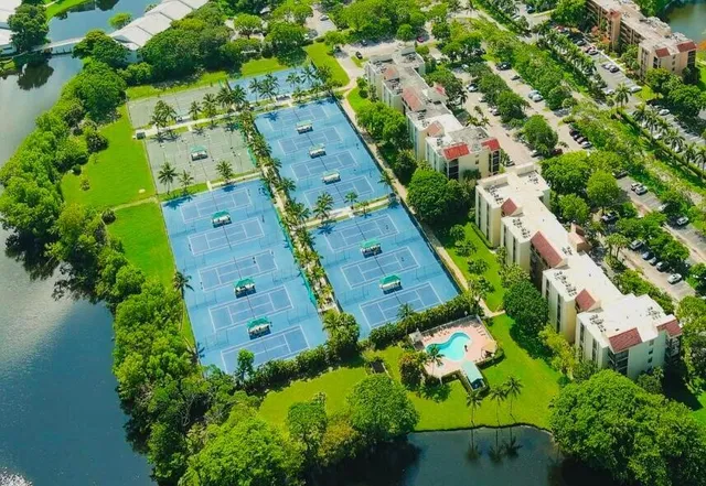 an aerial view of residential house with outdoor space and trees all around