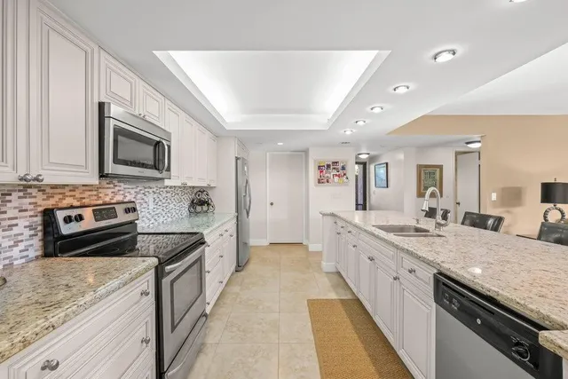 a large kitchen with stainless steel appliances granite countertop a lot of counter space