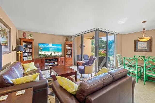 a living room with furniture a flat screen tv and a floor to ceiling window