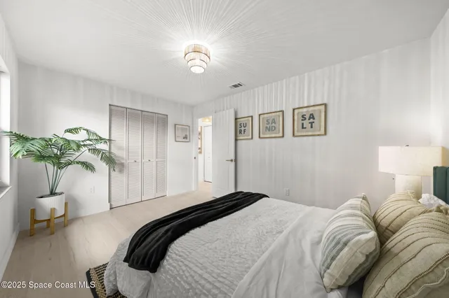 a bedroom with a bed and a potted plant