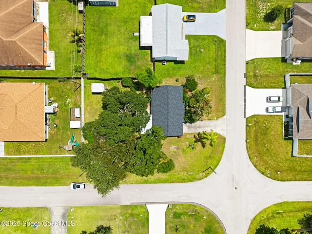 an aerial view of a swimming pool with a yard