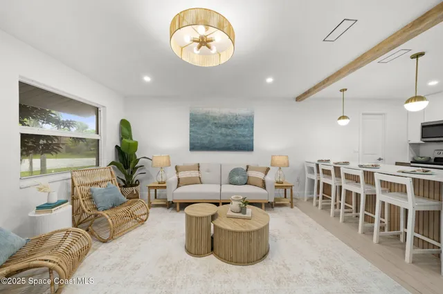 a living room with furniture kitchen view and a large window