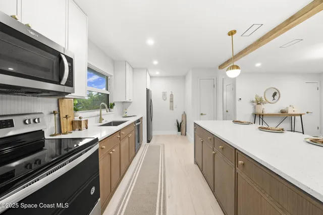 a kitchen with stainless steel appliances a sink stove and cabinets