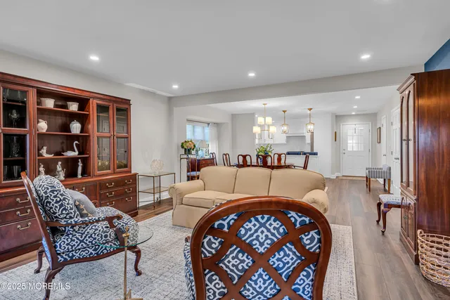 a living room with furniture and a dining table with bookshelf