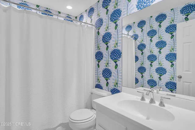 a bathroom with a sink and mirror with toilet