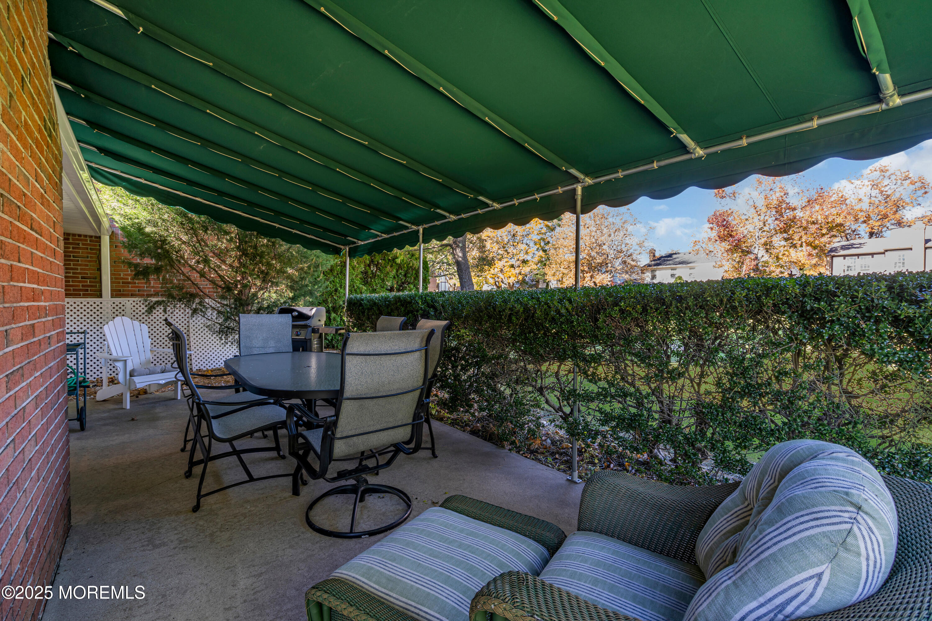 68 Maple Drive Spring Lake Heights, NJ 07762 - Photo 21 of 24 a view of patio with table and chairs under an umbrella with a small yard