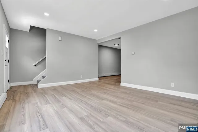 a view of an empty room with wooden floor