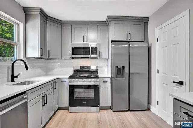 a kitchen with stainless steel appliances a refrigerator stove and sink