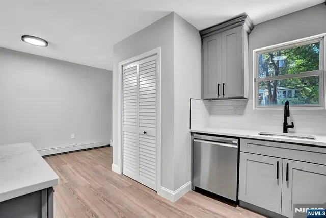 an empty room with wooden floor and fan