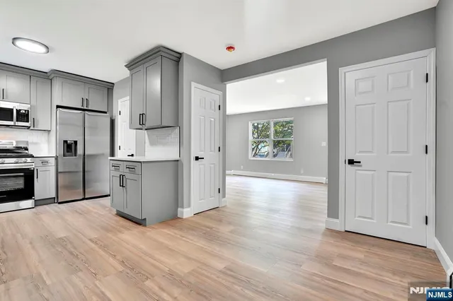 a view of a kitchen with wooden floor electronic appliances and window