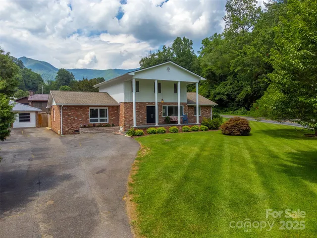 a front view of a house with a garden and trees