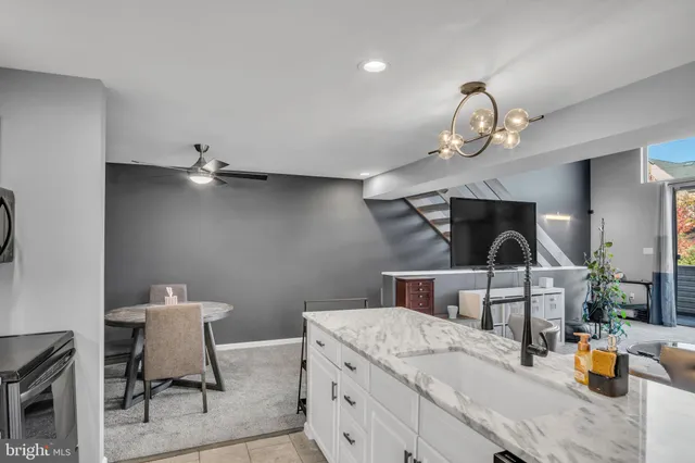 a kitchen with stainless steel appliances kitchen island granite countertop a refrigerator stove and sink