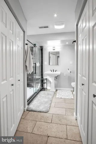 a bathroom with a sink mirror and glass door