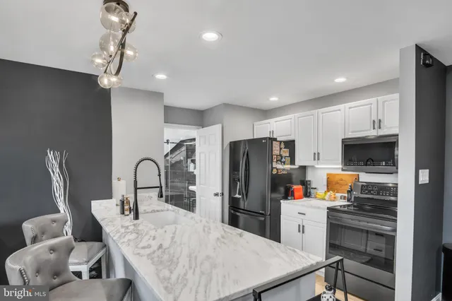 a kitchen with stainless steel appliances a refrigerator dining table and chairs