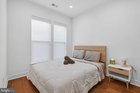 a bedroom with a bed and wooden floor