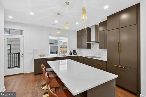 a kitchen with kitchen island a large counter top space and stainless steel appliances