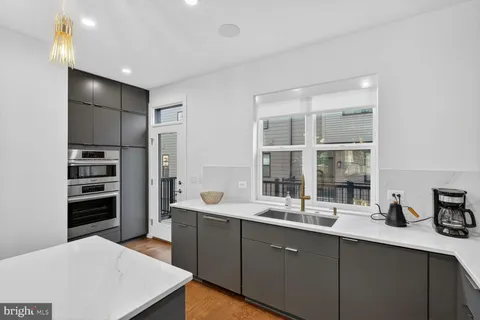a kitchen with stainless steel appliances a sink stove and cabinets