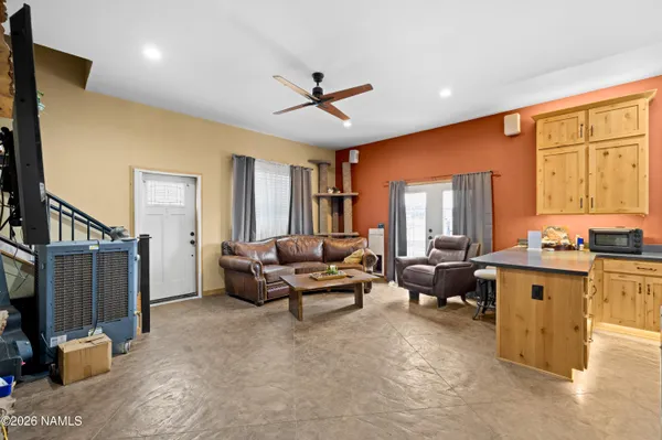 a living room with furniture two window and a flat screen tv