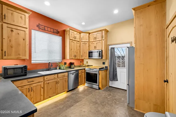 a kitchen with stainless steel appliances granite countertop a stove a sink and a refrigerator