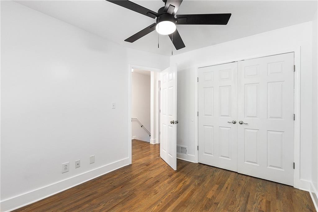 2232 Dunseath Avenue Northwest, Unit 309 Atlanta, GA 30318 - Photo 12 of 25 an empty room with wooden floor a ceiling fan and closet