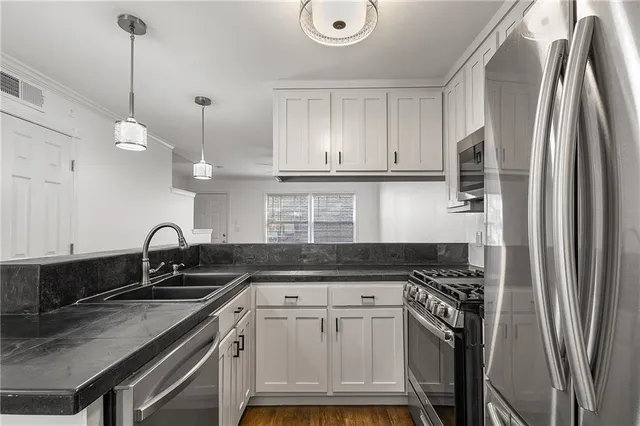 a kitchen with a sink a stove a refrigerator and cabinets