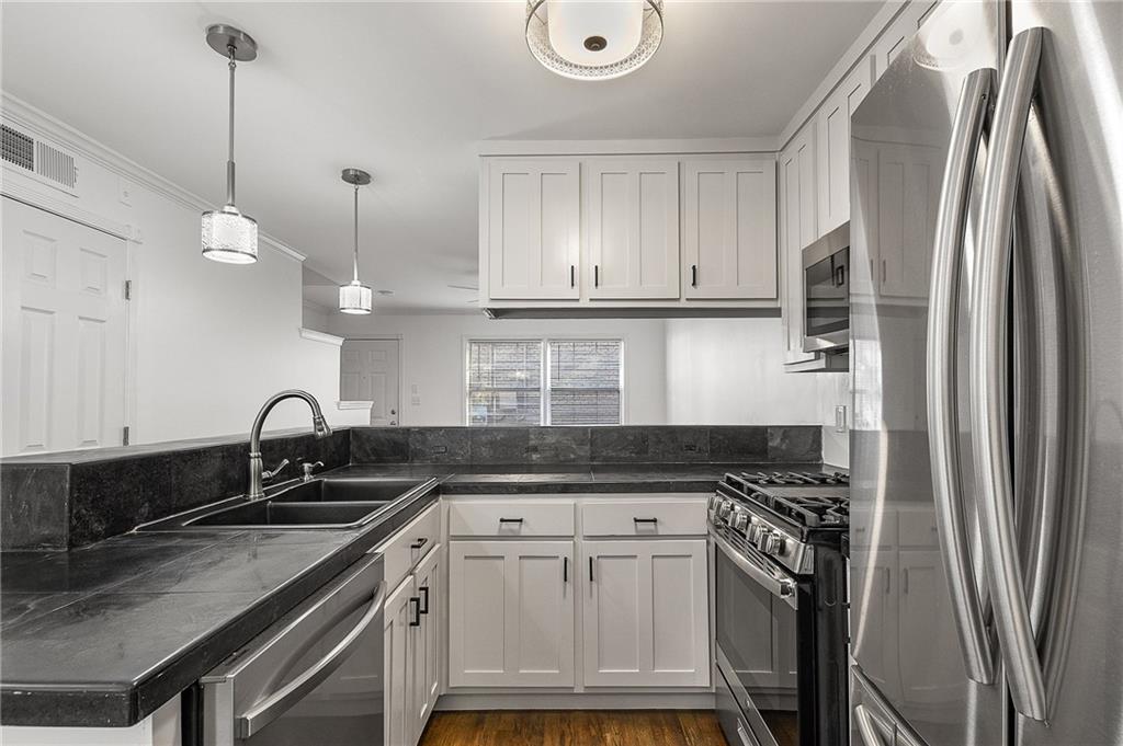 2232 Dunseath Avenue Northwest, Unit 309 Atlanta, GA 30318 - Photo 7 of 25 a kitchen with a sink a stove a refrigerator and cabinets