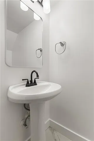 a bathroom with a sink a toilet and a mirror