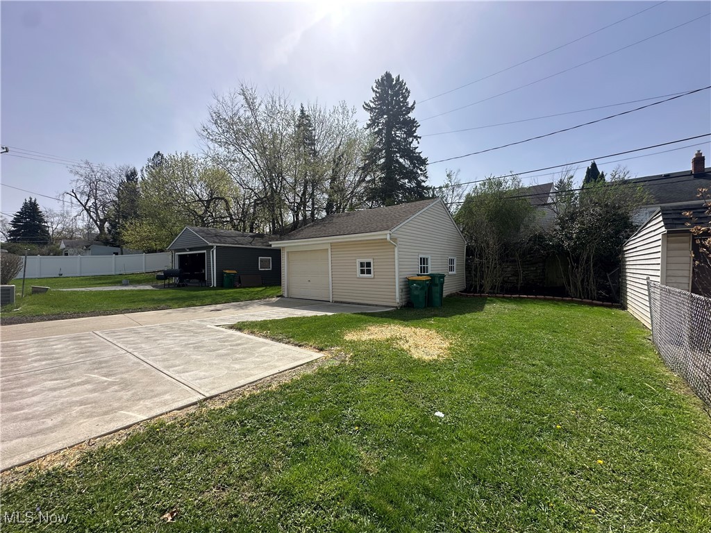 18230 Libby Road Maple Heights, OH 44137 - Photo 11 of 39 View of yard featuring driveway, an outdoor structure, fence, and a garage