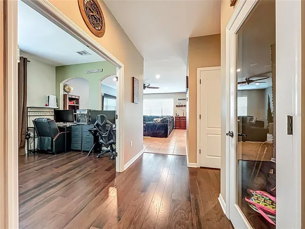 a view of a hallway with wooden floor and furniture