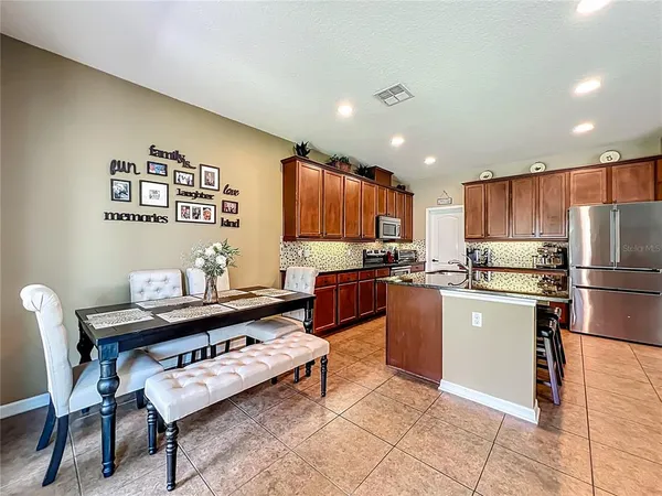 a kitchen with stainless steel appliances kitchen island granite countertop a sink and a refrigerator