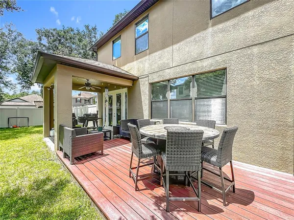 a roof deck with table and chairs and potted plants